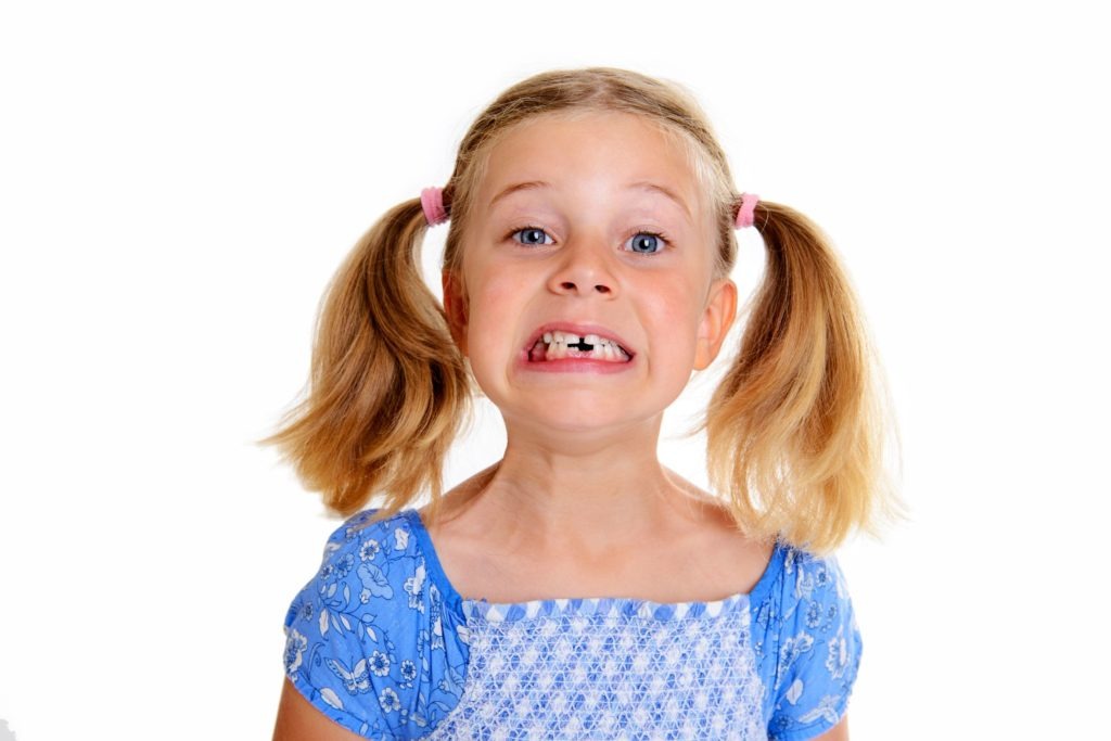 blonde girl with pig tails missing teeth