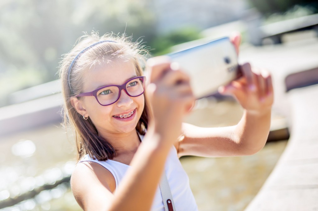 young girl with glasses taking a selfie