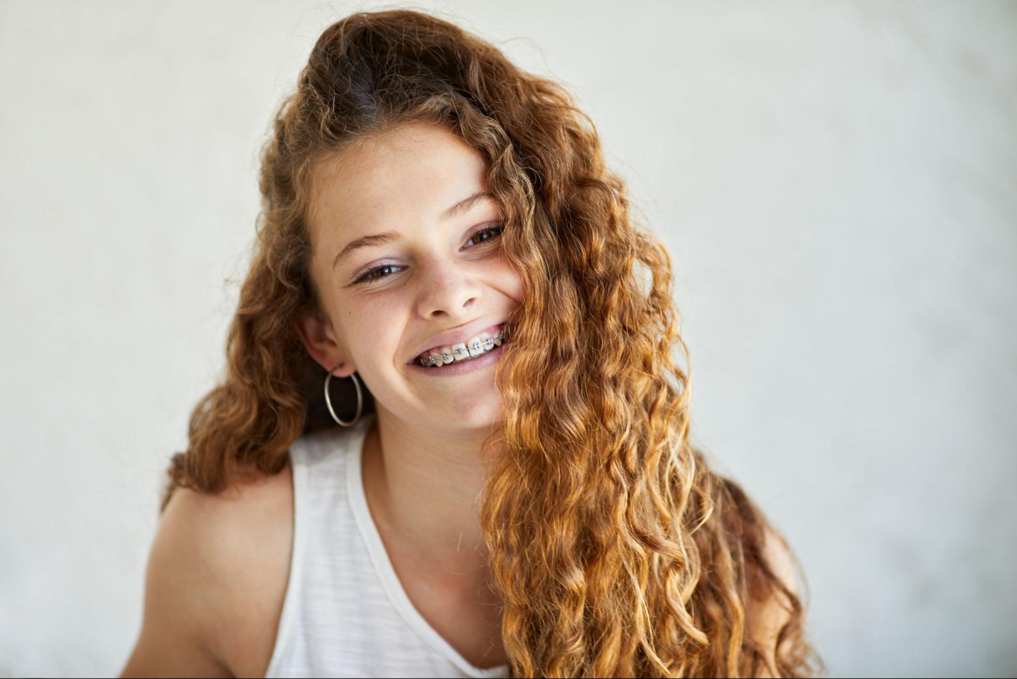 Patient smiling with metal braces in Sacramento orthodontic office